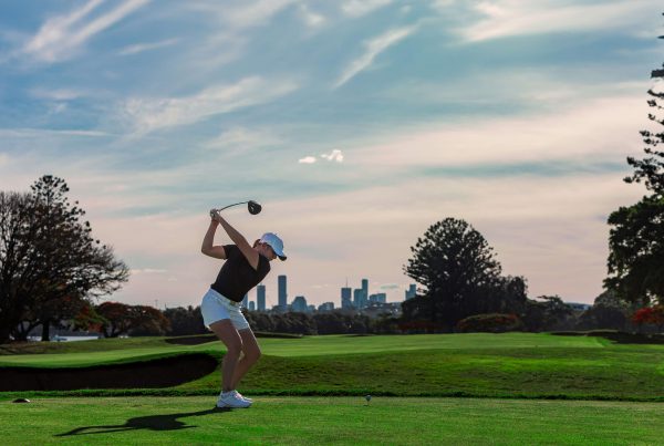 woman golfing with skyline